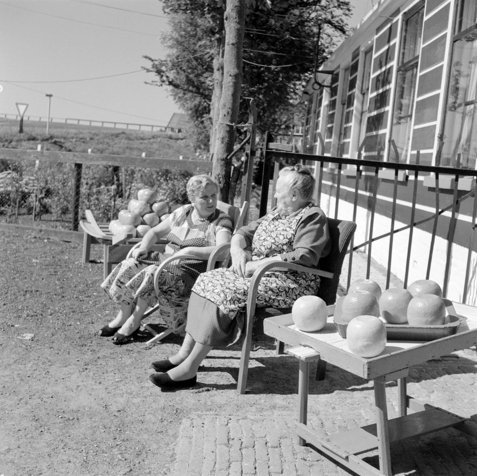 Vrouwen zitten in de zon te praten voor de Irene-Hoeve waar Edammer kaas wordt v, Bestanddeelnr 254-4000