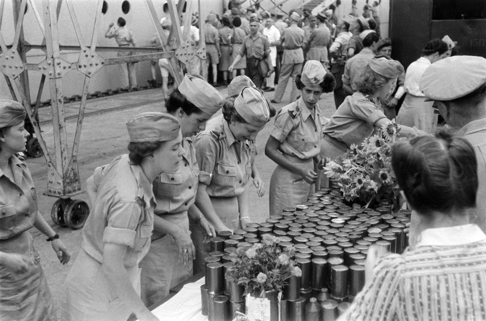 Vrouwenkorps KNIL (VK-KNIL) zet blikken gereed op een lange tafel, Bestanddeelnr 71-1-3