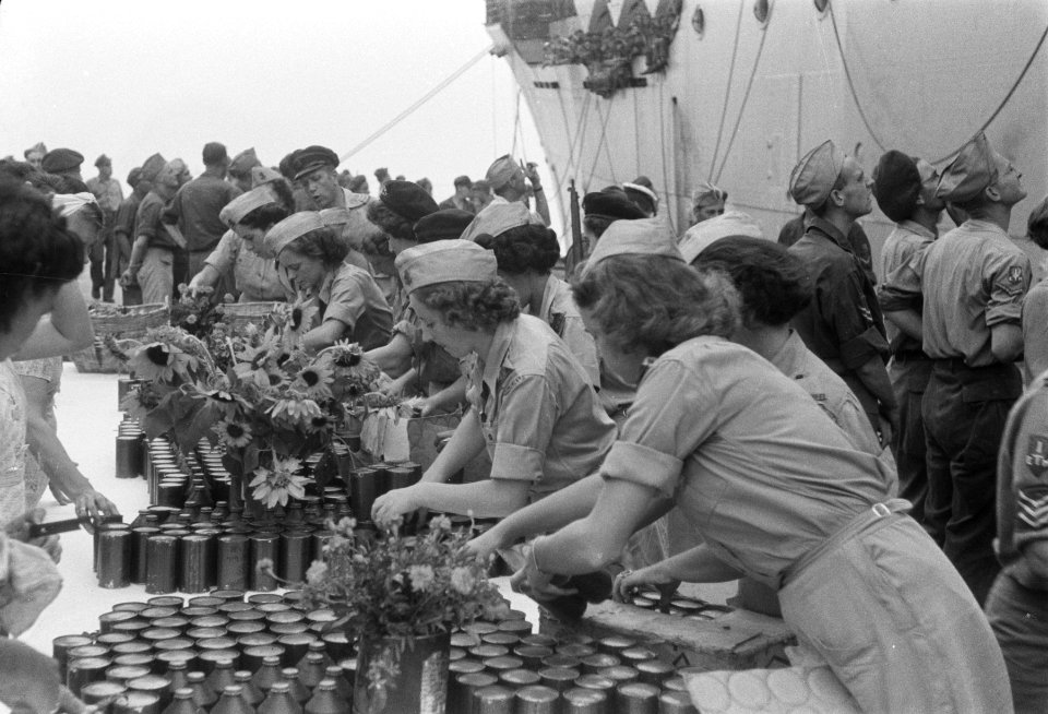 Vrouwenkorps KNIL (VK-KNIL) zet blikken gereed op een lange tafel, Bestanddeelnr 71-1-1