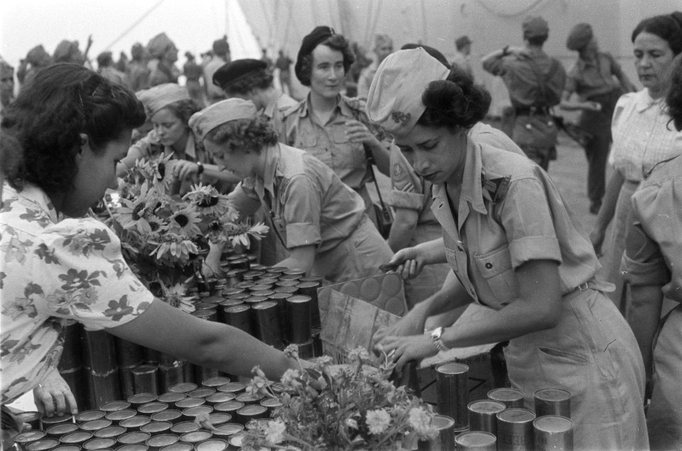Vrouwenkorps KNIL (VK-KNIL) zet blikken gereed op een lange tafel, Bestanddeelnr 71-1-2