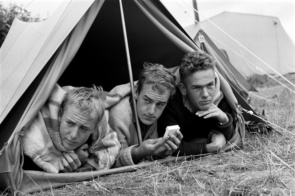 Vakantie in de camping Drie kampeerders in tent luisteren naar de weersberichte, Bestanddeelnr 915-4686