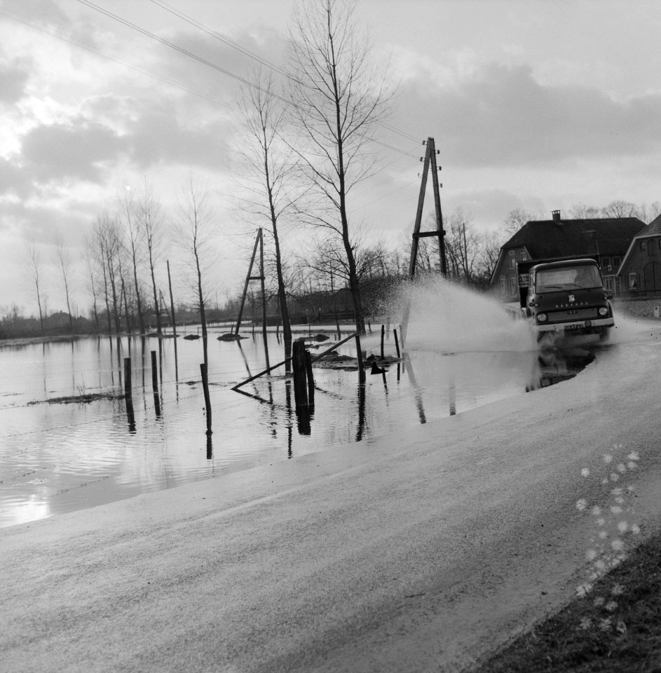 Wateroverlast in de Gelderse Vallei auto rijdend langs een ondergelopen weiland, Bestanddeelnr 918-5508