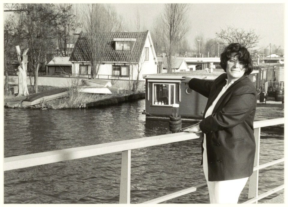 Waarderhaven met woonboten. Mevrouw Van Rossum wijst haar boot aan. NL-HlmNHA 54031588