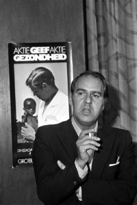 W Duys met poster voor televisie-uitzending Geef gezondheid, Bestanddeelnr 924-8494