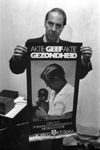 W Duys met poster voor televisie-uitzending Geef gezondheid, Bestanddeelnr 924-8492