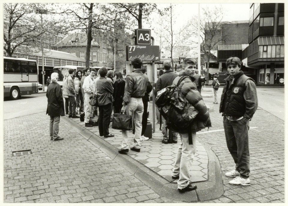Wachtende buspassagiers op het Stationsplein, ziende naar het oosten. NL-HlmNHA 54032028
