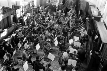 Studenten Orkest oefent in kerk van Bergen. De paukenist met ijsmuts maakt handi, Bestanddeelnr 920-9738
