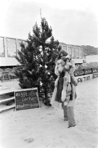 Slecht zomerweer kerstboom op strand in Bergen aan Zee dame in bontjas, Bestanddeelnr 929-2503