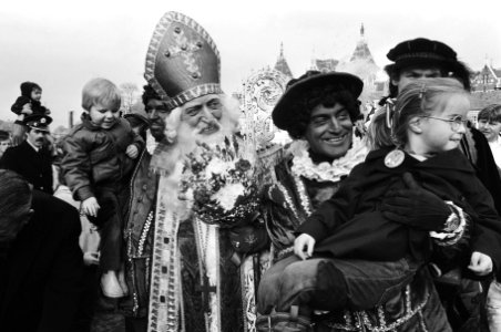 Sinterklaas met een kind op de arm en zwarte piet, Bestanddeelnr 932-3987