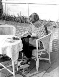 Van de Polls vrouw Nell Langlais aan het borduren op een terras bij Duin en Daal, Bestanddeelnr 189-1287