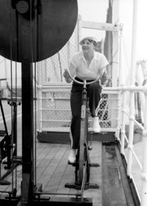 Van de Polls vrouw Nell Langlais op een krachtfiets op het cruiseschip MS Colomb, Bestanddeelnr 190-0101