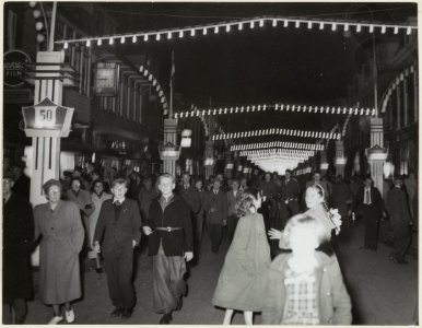 Veel belangstelling in de Gen. Cronjéstraat bij avond, met feestverlichting t.g.v. het 50-jarig bestaan van de winkelstraat. NL-HlmNHA 54004187