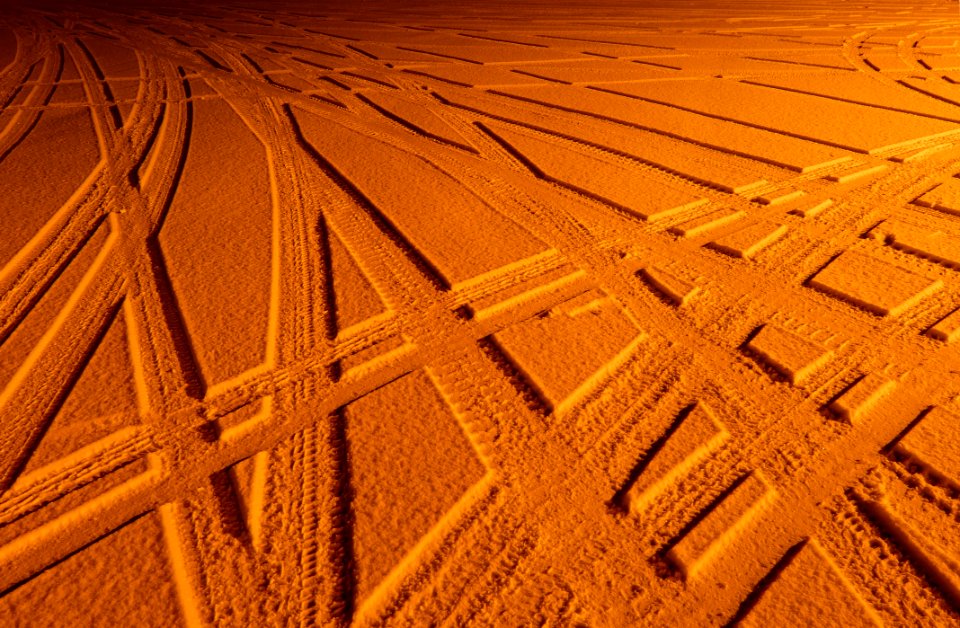 Tire tracks in snow under sodium light 4