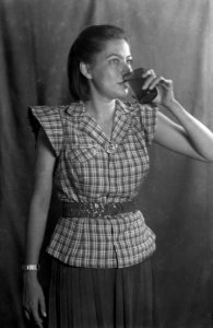 Vrouw poseert staande en drinkt een glas water, Bestanddeelnr 8705