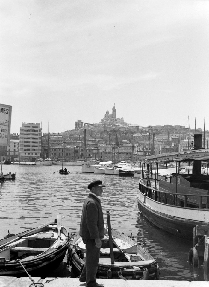 Visser in de oude haven, met op de achtergrond de Notre-Dame de la Garde, Bestanddeelnr 191-0127