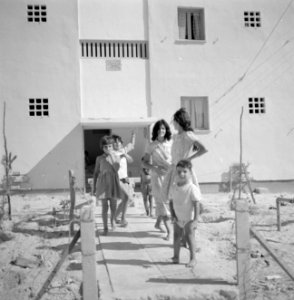 In een nieuwbouwwijk in Dimona Vrouwen en kinderen voor een flatgebouw met bove, Bestanddeelnr 255-3573