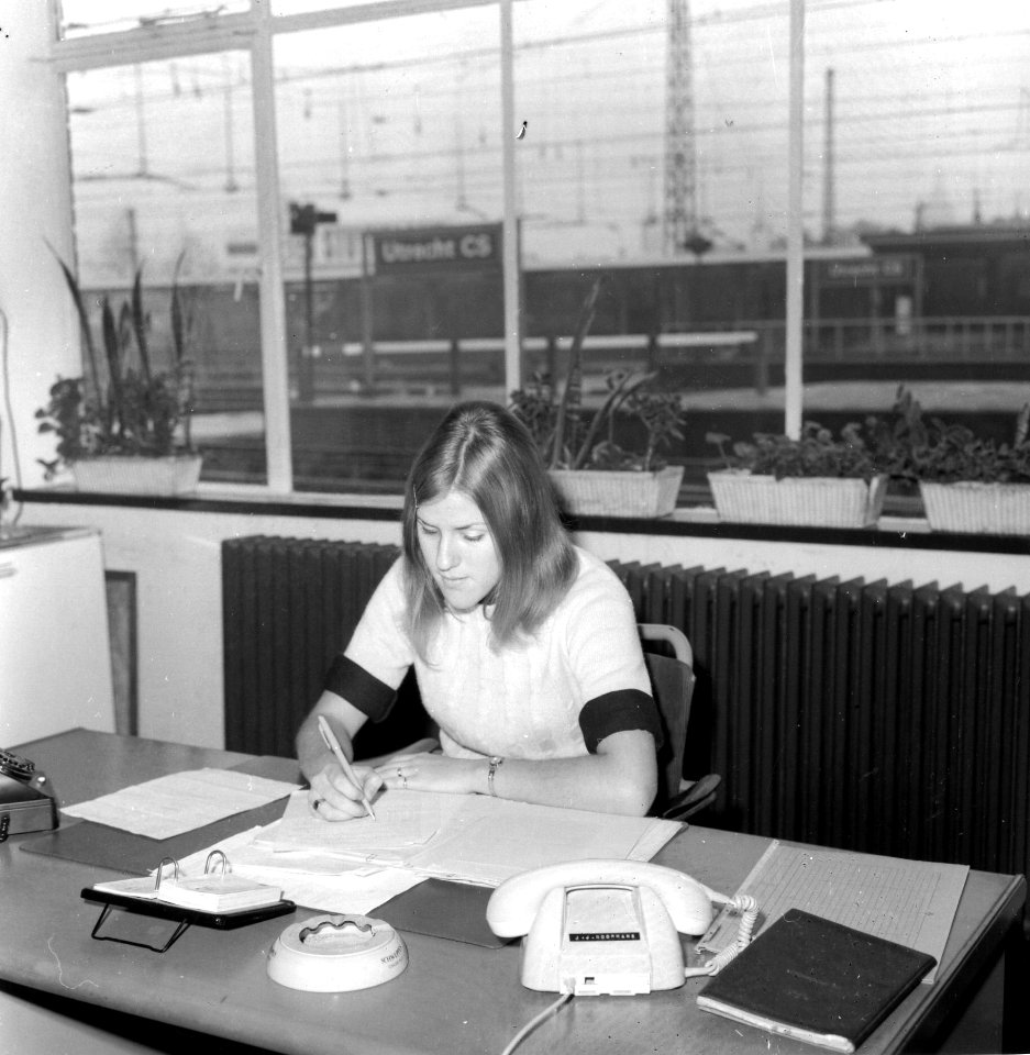 HUA-166710-Afbeelding van een medewerkster op het goederenkantoor van het N.S.-station Utrecht C.S. te Utrecht. N.B. Op de telefoon staat de naam J.J. Koopmans