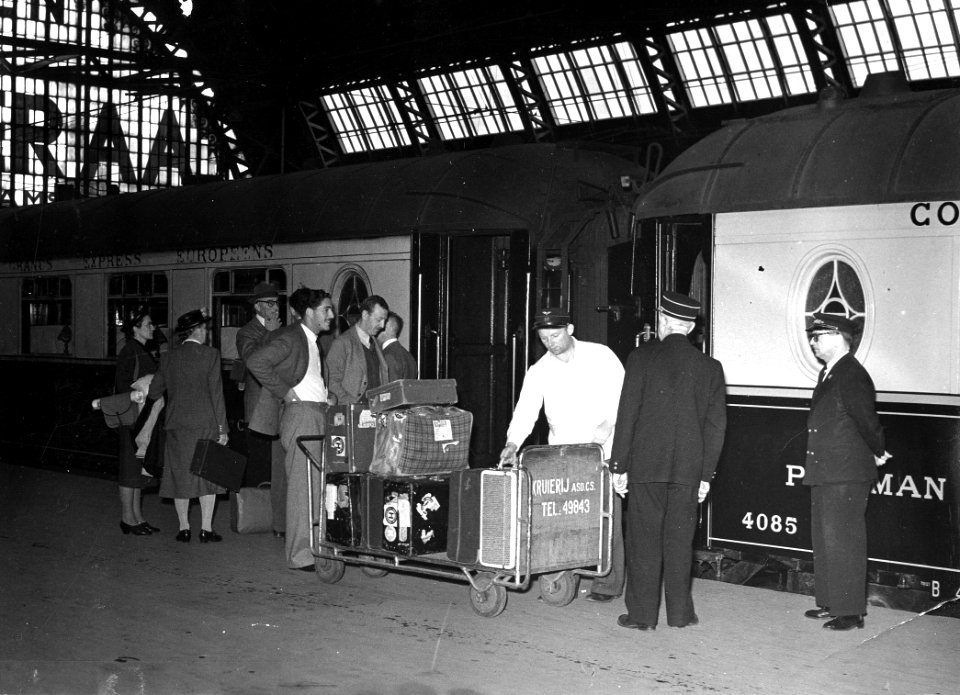 HUA-166681-Afbeelding van een kruier met een bagagekar bij een trein bestaande uit rijtuigen van de Compagnie Internationale des Wagons-Lits (rechts restauratierijtuig nr. 4085) langs een perron van het N.S.-sta