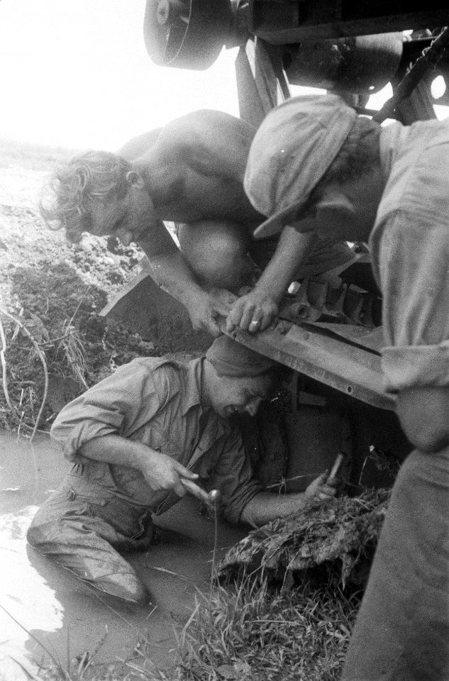 In de modder probeert een militair met hamer en beitel iets los te bikken van e, Bestanddeelnr 256