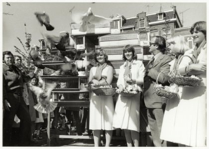 Temidden van de Haarlemse Bloemenmeisjes heropende loco-burgemeester P.W. Voskuilen het vernieuwde Stationsplein, waarbij 500 postduiven werden gelost. NL-HlmNHA 54005139