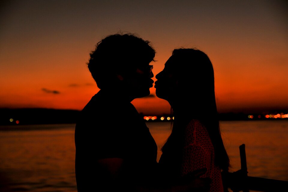 Backlit people kiss