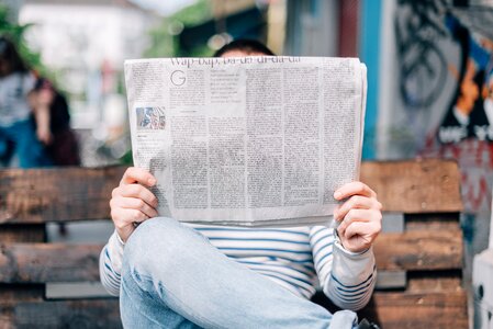 Newspaper sitting bench photo