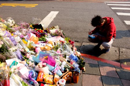 Kneeling Man Writting Pray Card at Liu Murder Place 20160330 photo