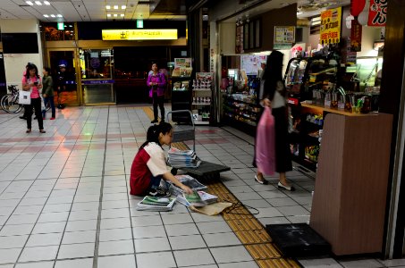 Female Seller of 7-Eleven No.1 Taipei Store Stacking Newpapers on Cart in Morning 20151121 photo