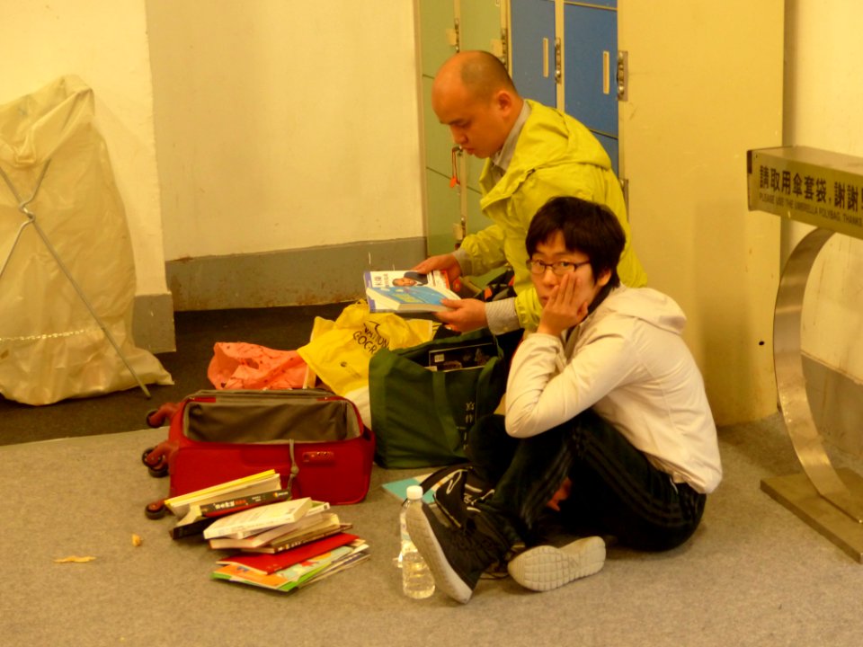 2014TIBE Day6 Hall1 Visitors Set on Floor Looking Books 20140210
