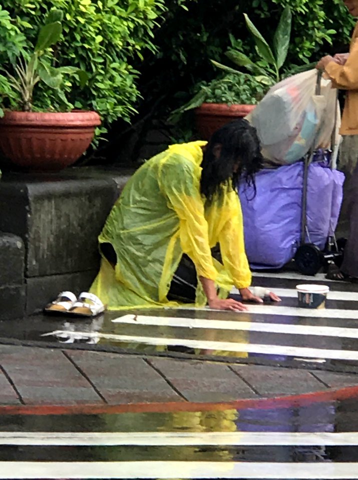 Beggar with Rain wear in Entrance of NTU Hospital West Site 20170509