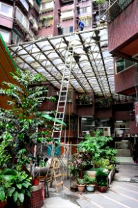 Worker Cleaning Sun Roof of Shin Kong Minsheng Square Central Court 20160727a