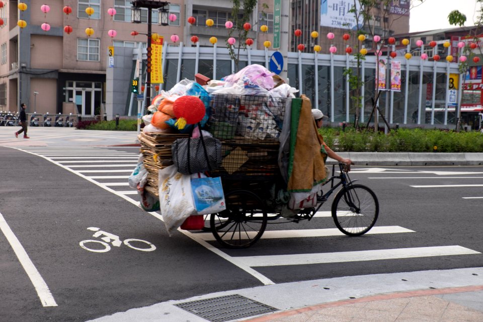 Woman Riding Tricycle Loaded Recycle Items in Songshan Road, Songshan District, Taipei 20150316