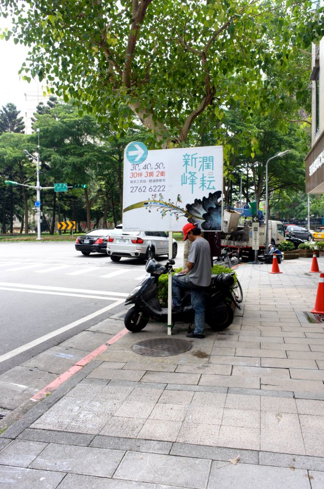 Real Estate Advertising Man Reading Notebook at Sidewalk of Section 5, Minsheng East Road, Taipei 20150613