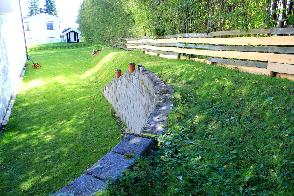 Støttemur mot plen og skråning