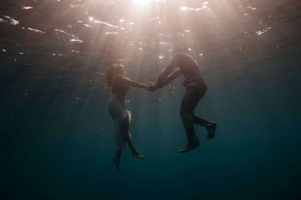 Holding hands swimming underwater