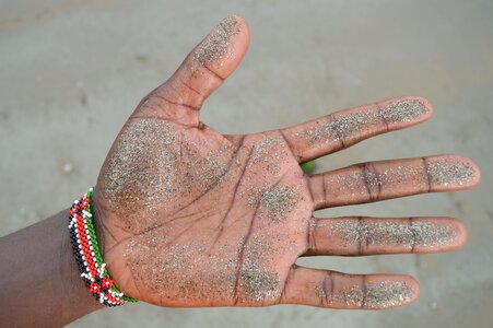 Hand fingers gray sand photo