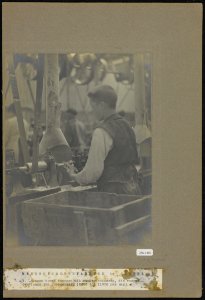 1 Jongen boort knopen uit runderbeenderen, die vooraf overlangs zijn doorgezaag, Bestanddeelnr 256-1345
