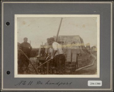 11 Arbeiders bedienen de handpers voor het maken van bakstenen, Bestanddeelnr 256-1380