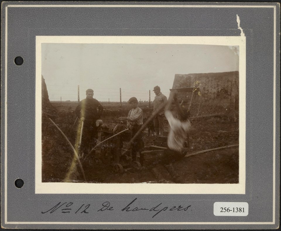 12 Arbeiders bedienen de handpers voor het vormen van stenen, Bestanddeelnr 256-1381