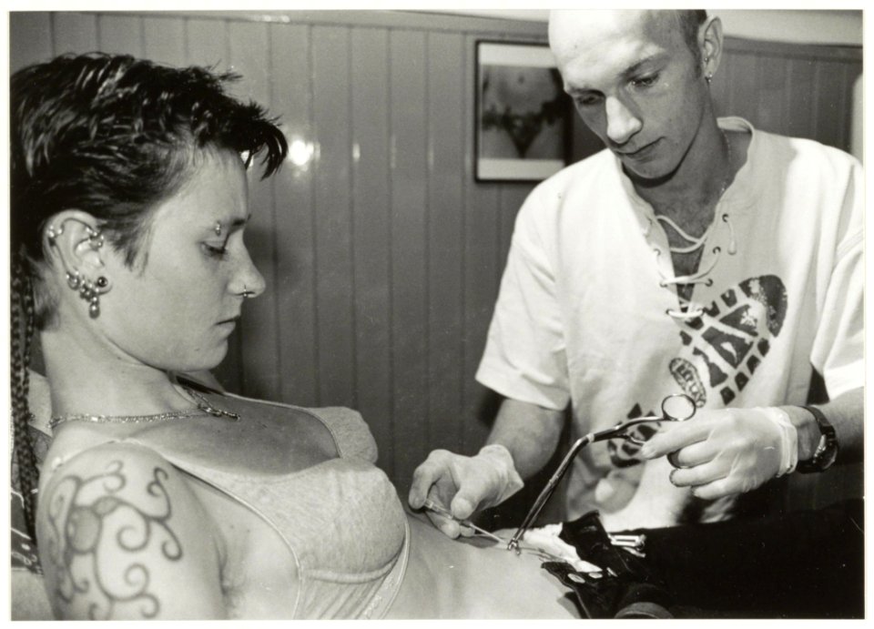 'Rings of pleasure' Piercing Studio in de Schagchelstraat. Foto Eigenaar Rob van Rijn plaatst een navelpiercing bij Saskia Harman. NL-HlmNHA 54037207
