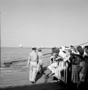 'Afhalers' achter een dranghek op de kade, wachtend op een schip (zie ook 255-21, Bestanddeelnr 255-2178