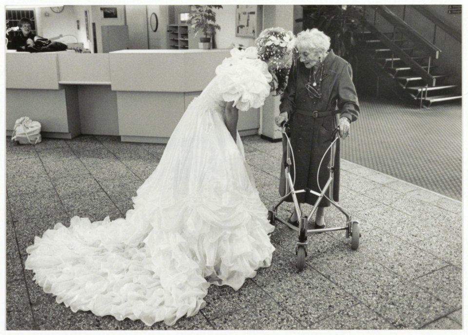 23-jarige bruid Ingrid Willemse en haar 104-jarige overgrootmoeder W. de Laat-Fabel in de hal van het Reinaldahuis. NL-HlmNHA 54034050