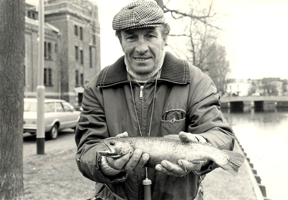 Gerrit van der Kuyl met zijn gevangen Forel, gevangen in de Leidsevaart ter hoogte van de Stadsschouwburg. Aangekocht in 1983 van United Photos de Boer bv. - Negatiefnummer 22833 k 9. - Gepu, NL-HlmNHA 54013834