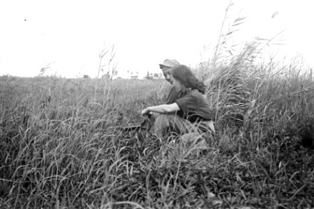 Indonesische man en meisje in uniform zitten samen in een veld. De man houd een , Bestanddeelnr 6082