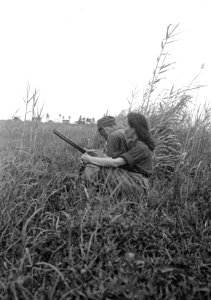 Indonesische man en meisje in uniform zitten samen in een veld De man houd een , Bestanddeelnr 6083