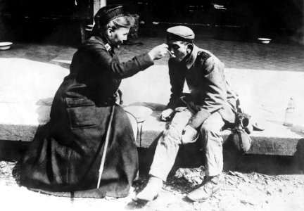 Una enfermera de la Cruz Roja francesa ayuda a un mendigo,…