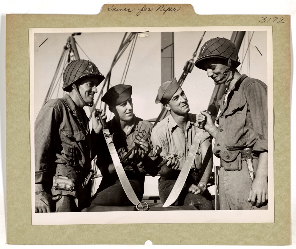 U.S. Coast Guardsmen compare blades, varying from machetes…
