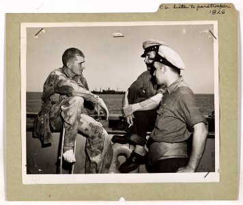A relaxing U.S. paratrooper tells two U.S. Coast Guardsmen…