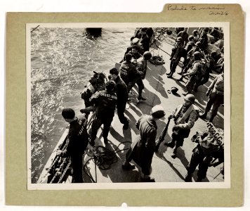 Coast Guardsmen line the rails to give a hand to G.I. Joes…