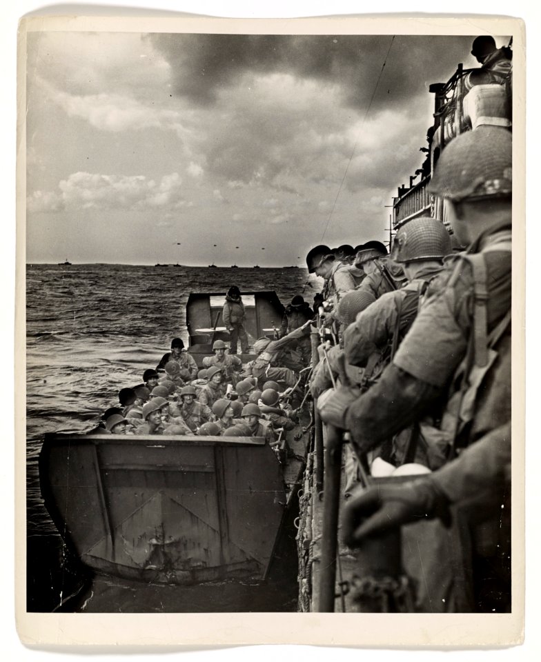 American invaders clamber from a Coast Guard LCI into a la…